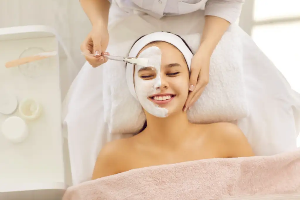 A woman enjoying a relaxing facial session as part of an acne treatment procedure.