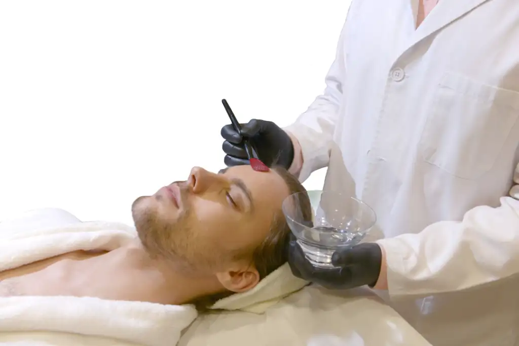 A professional performing a medspa treatment on a client using a precision brush application technique.