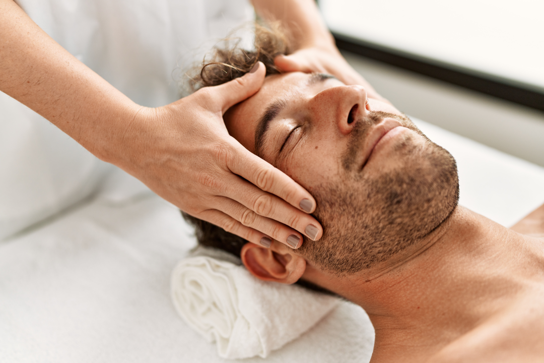 A man receiving a professional facial massage during a facial for men treatment.